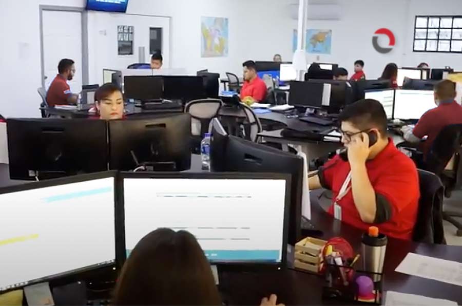 Customer service people in office answering phones on computer