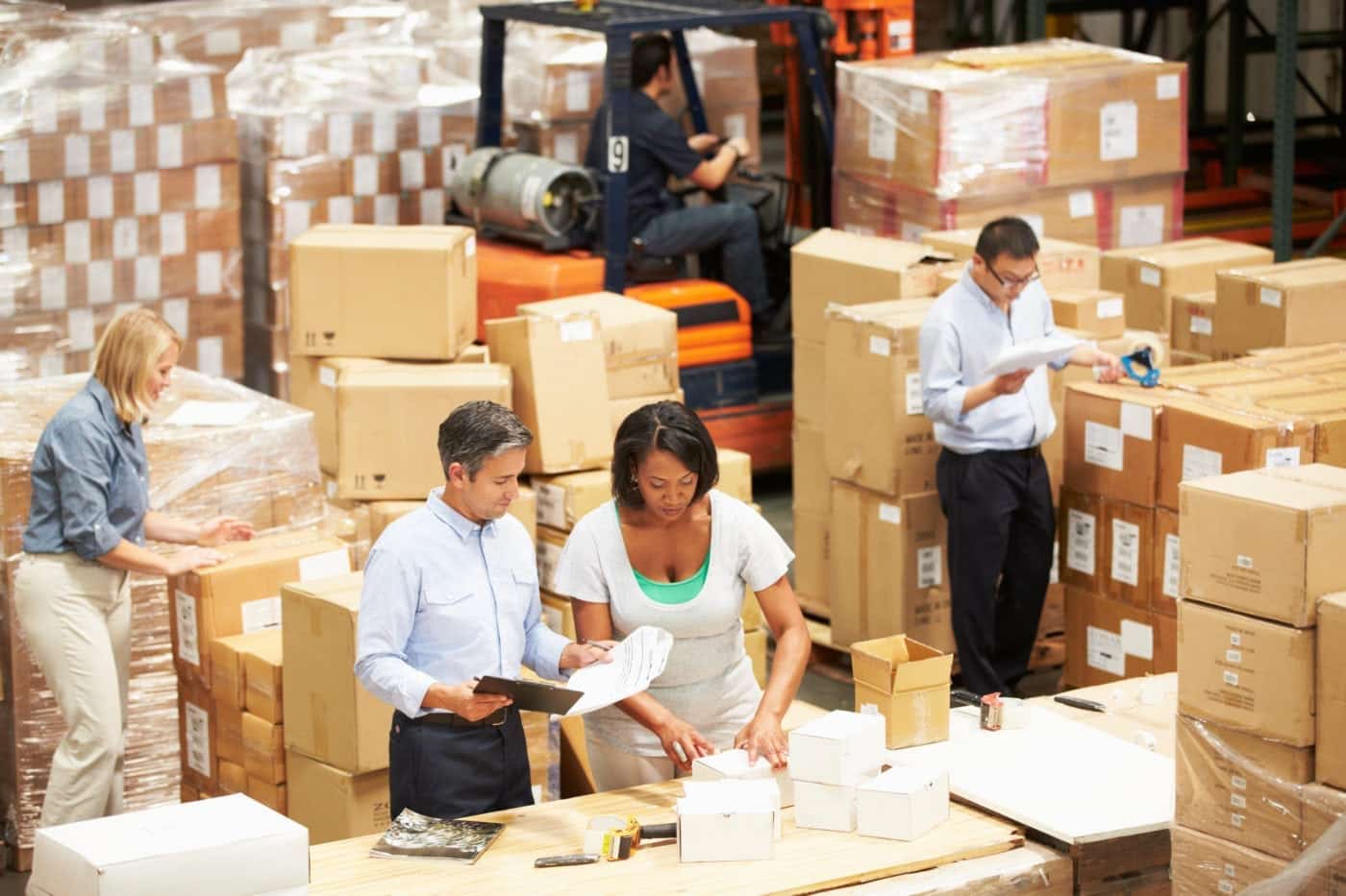 team employees working in warehouse with packages
