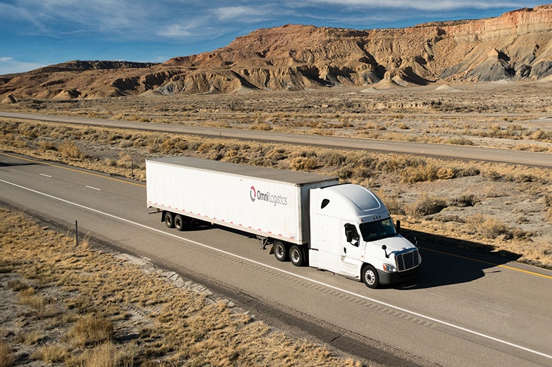 truck with omni logistics logo driving on freeway